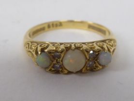 An 18ct gold ring, set with three cabochon opals, interspersed with diamonds