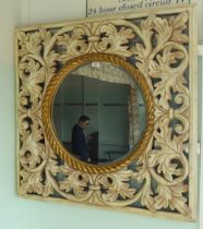 A shabby-chic cream coloured and painted gilt framed mirror with bold foliate decoration, set with a