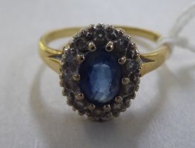 An 18ct gold cluster ring, set with a central sapphire, surrounded by diamonds