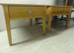 A pair of modern light oak single drawer lamp tables, raised on square, tapered legs  20"h  24"w