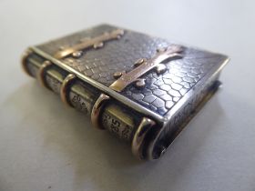 A late 19thC Continental novelty bi-coloured and textured metal book design vesta case,