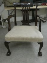 A Georgian style mahogany framed elbow chair with a pierced splat, the upholstered seat raised on