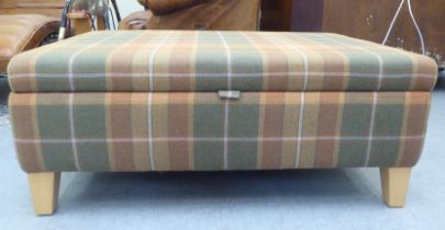 A modern rectangular box ottoman with a hinged lid, upholstered in autumnal coloured check fabric,