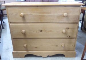 A modern pine three drawer dressing chest, raised on bracket feet  32"h  40"w