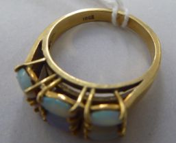 A yellow metal ring, set with two banks of three opals  stamped 18ct