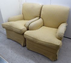 A pair of modern cottage style armchairs with scrolled backs and enclosed arms, upholstered in