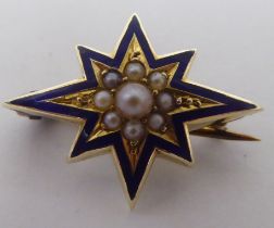 A yellow metal starburst brooch, decorated with pearls and blue enamel