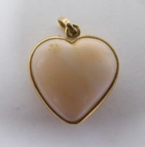 A coral pendant, fashioned as a love heart, set in a yellow metal mount  stamped K18