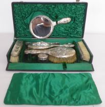 Silver backed dressing table items, decorated with cherubs  mixed marks, in a fitted case