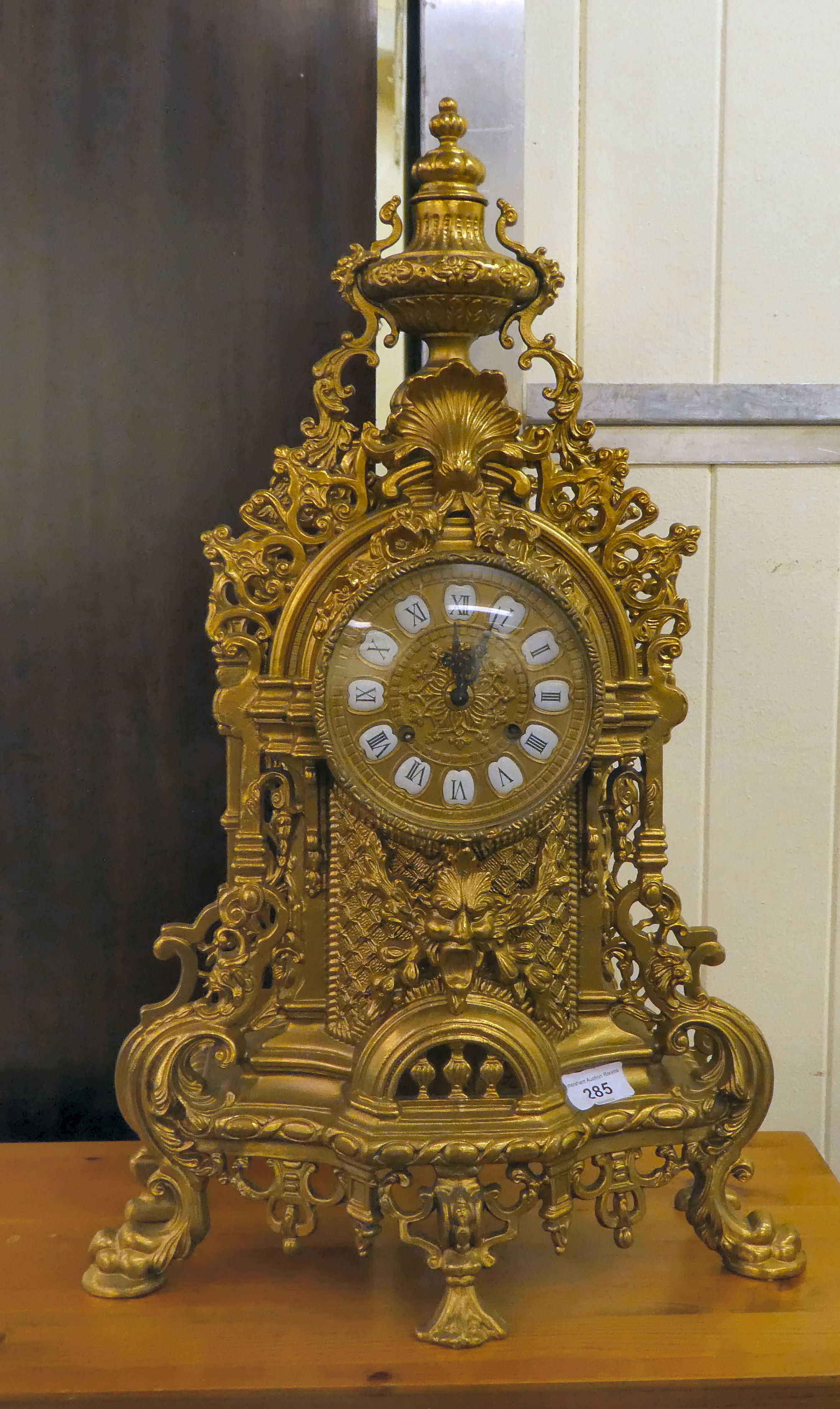 A modern Victorian design, gilt metal cased mantel clock of ornate architectural design, faced by