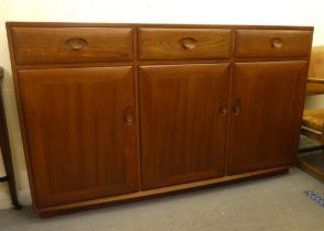 An Ercol mid brown elm sideboard with three drawers and three doors, on a plinth  37"h  61"w