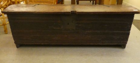 A mid 18thC boarded oak chest with a hinged lid, raised on planked feet  17"h  51"w
