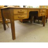 A 1930s oak desk with four drawers, raised on block legs  30"h  62"w