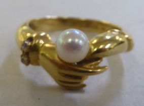 An 18ct gold friendship ring, set with a cultured pearl
