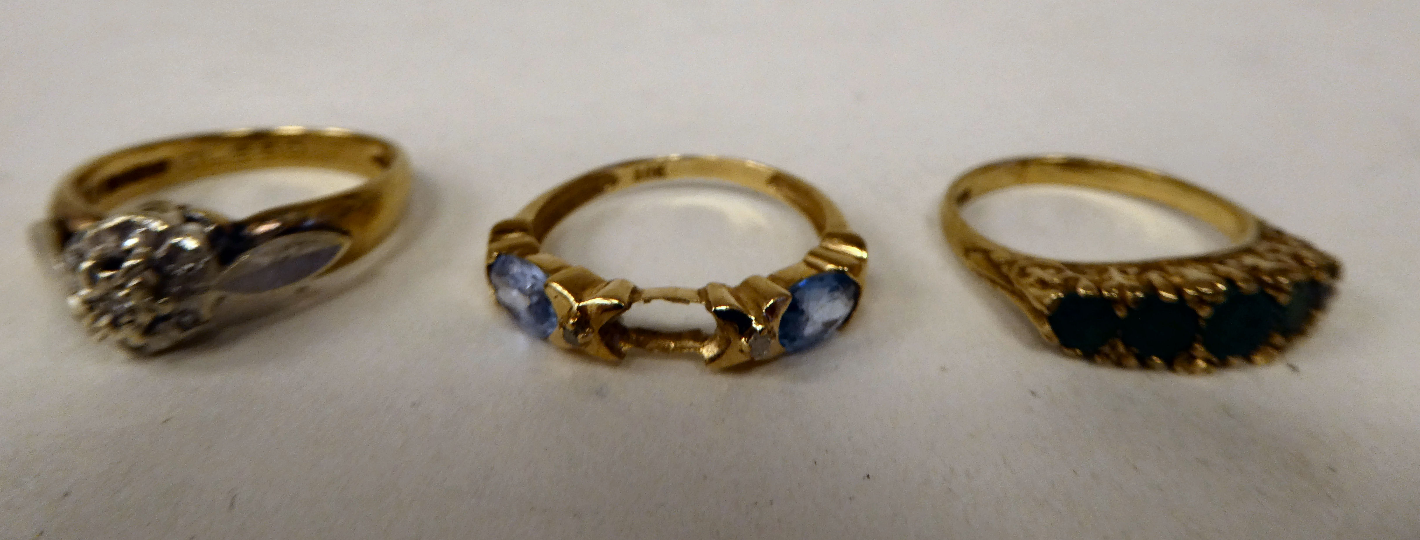 Three variously designed, 9ct gold rings: to include one set with aquamarine coloured stones