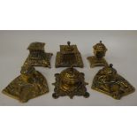 Six variously designed, early/mid 20thC decoratively cast brass desktop lidded inkwells