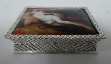 A silver coloured metal pin box, the hinged lid featuring an enamelled study, a reclining nude