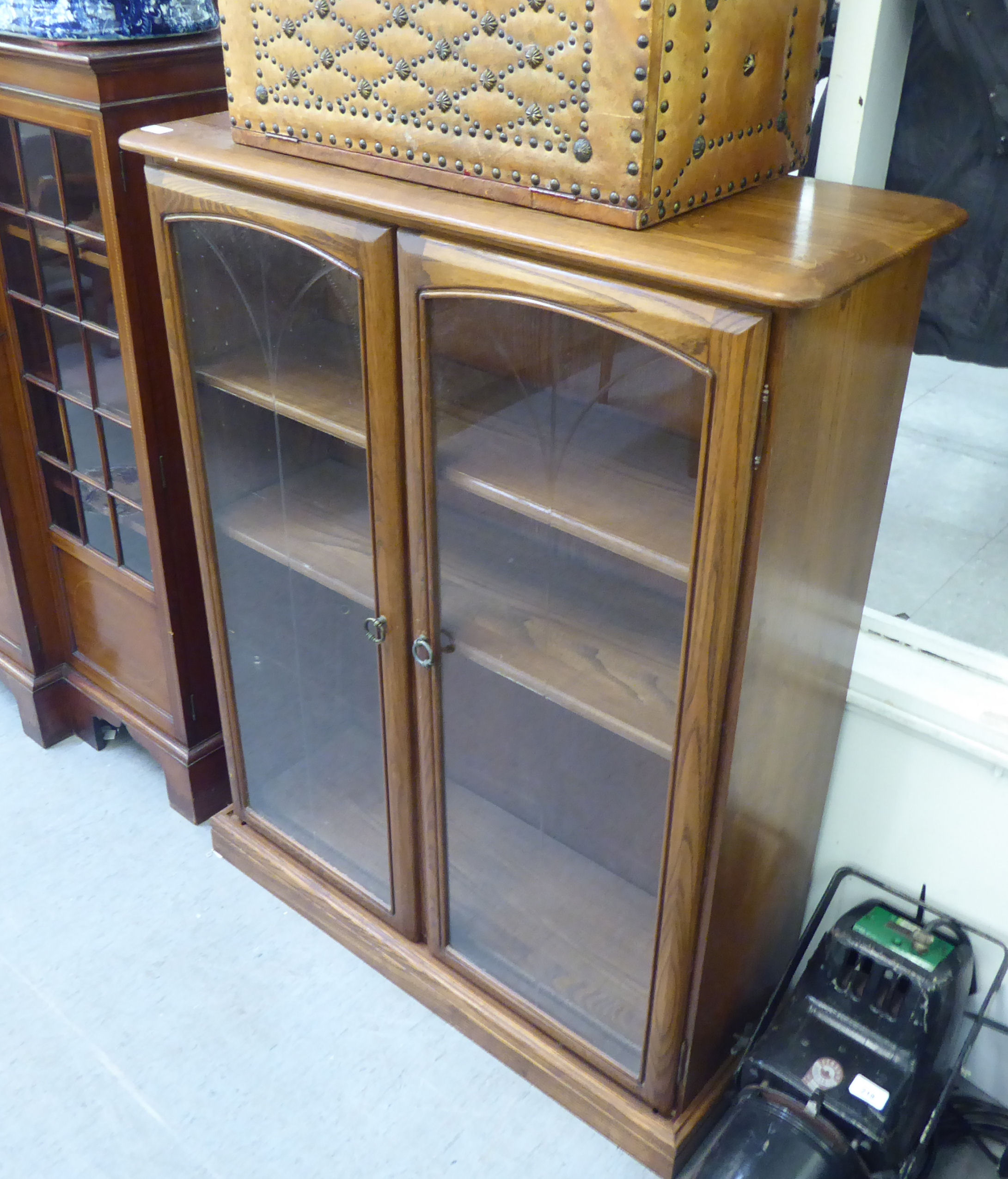 An Ercol mid tone elm cabinet with two glazed doors, on a plinth  45"h  37"w - Image 2 of 2