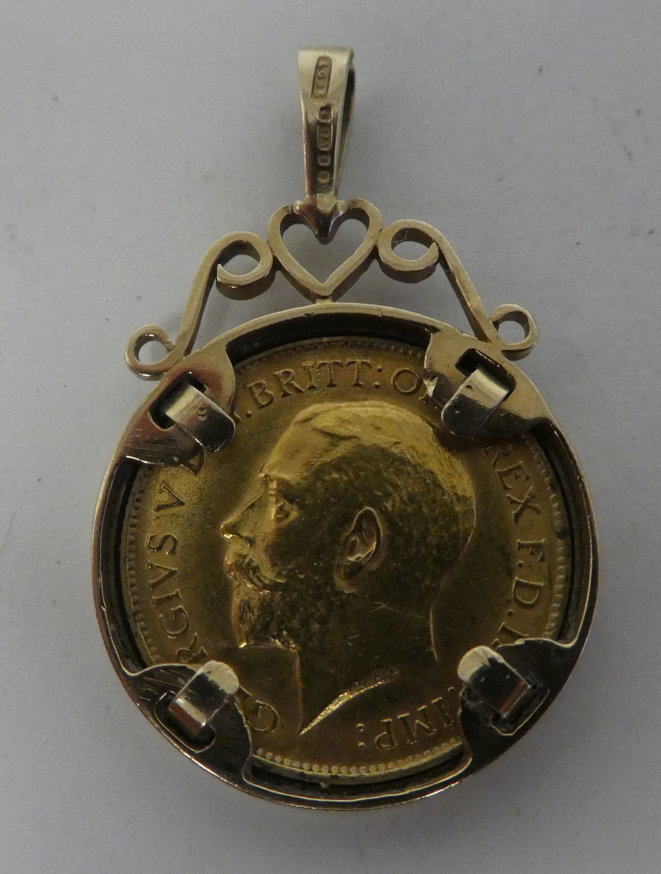 A George V half sovereign, St George on the obverse  1914, in a 9ct gold, scrolled pendant mount