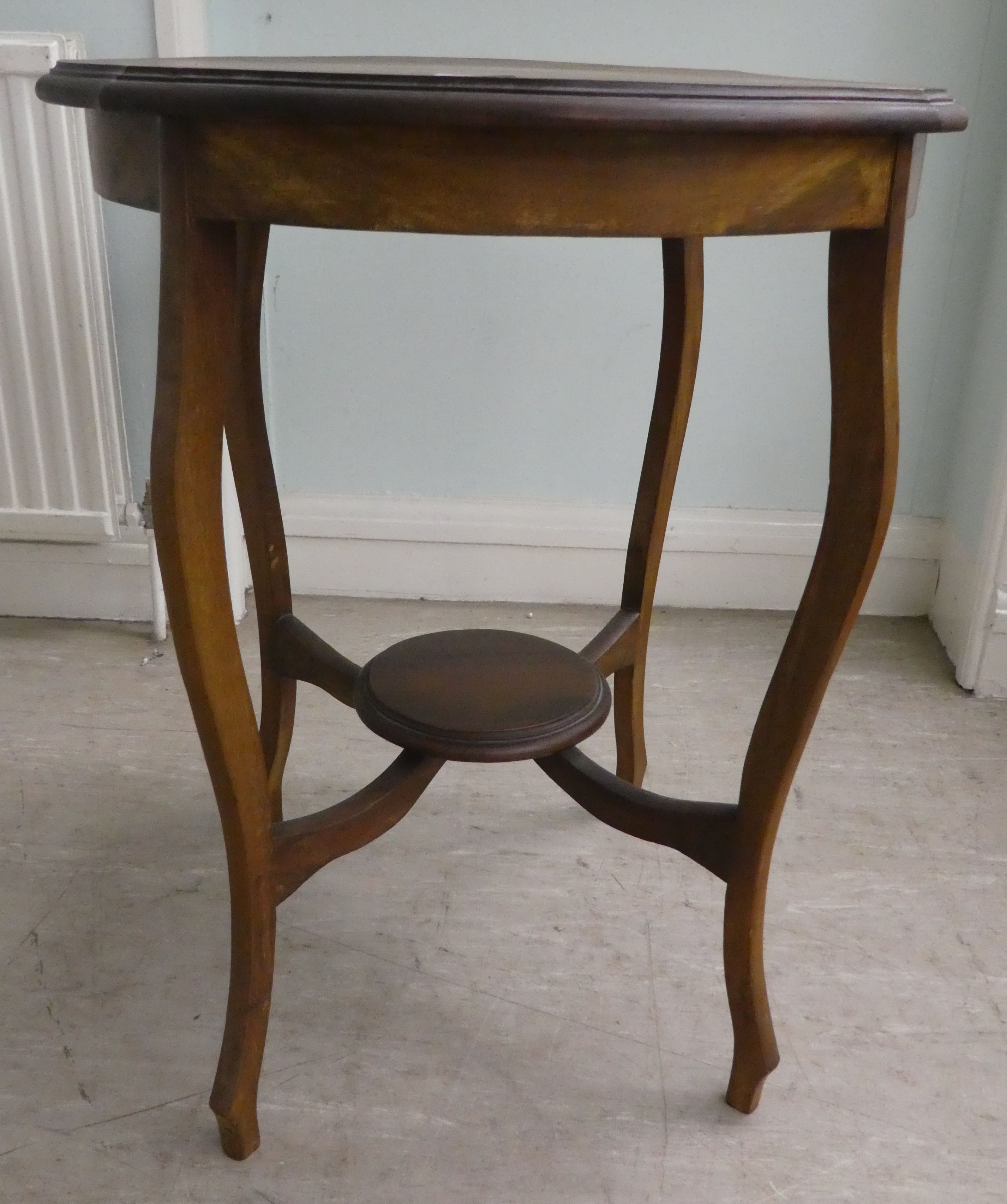 A mid 20thC mahogany occasional table, having a serpentine outlined top, raised on cabriole legs,