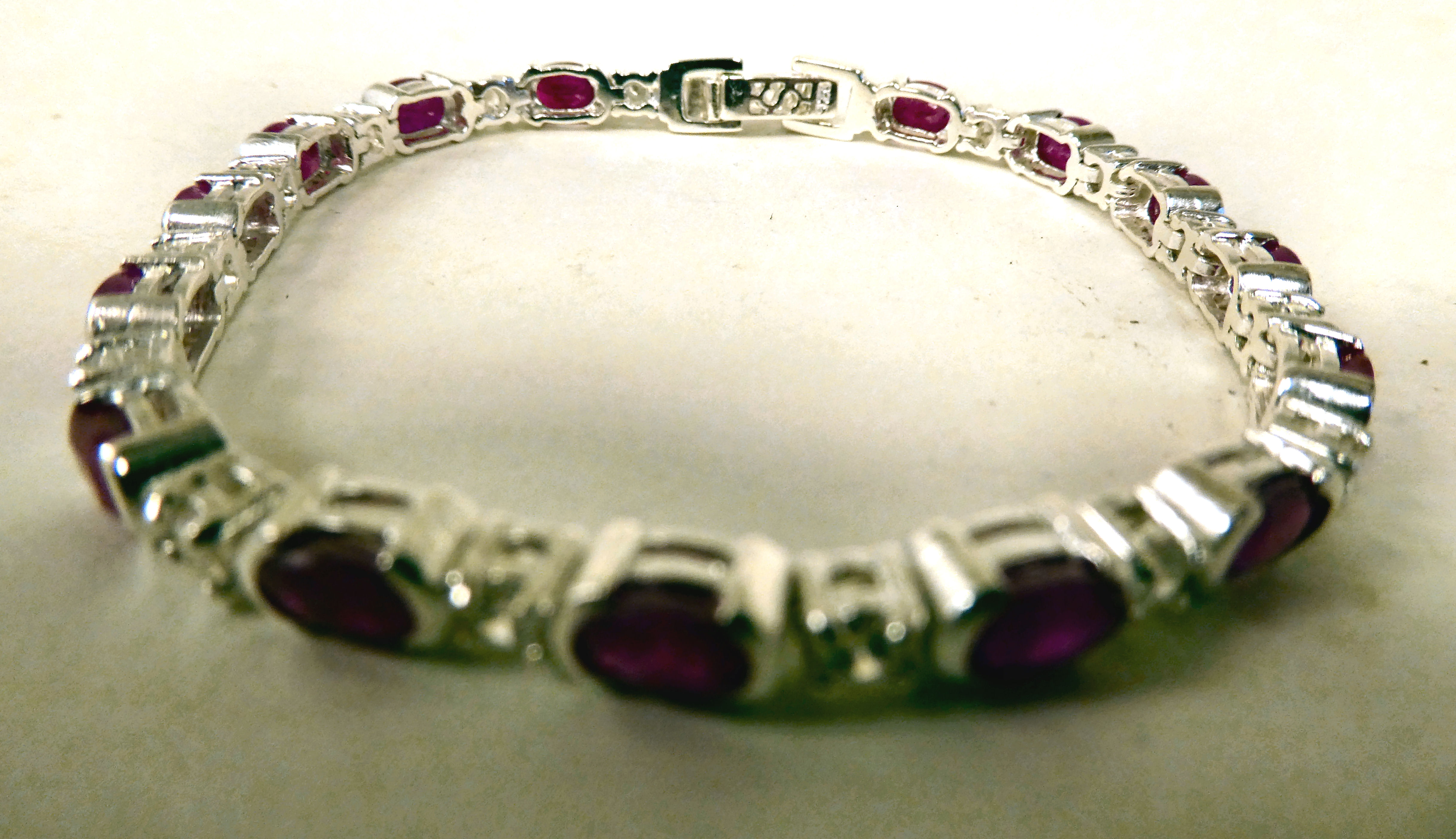 A white metal bracelet, set with cubic zirconia and rubies
