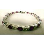 A white metal bracelet, set with cubic zirconia and rubies