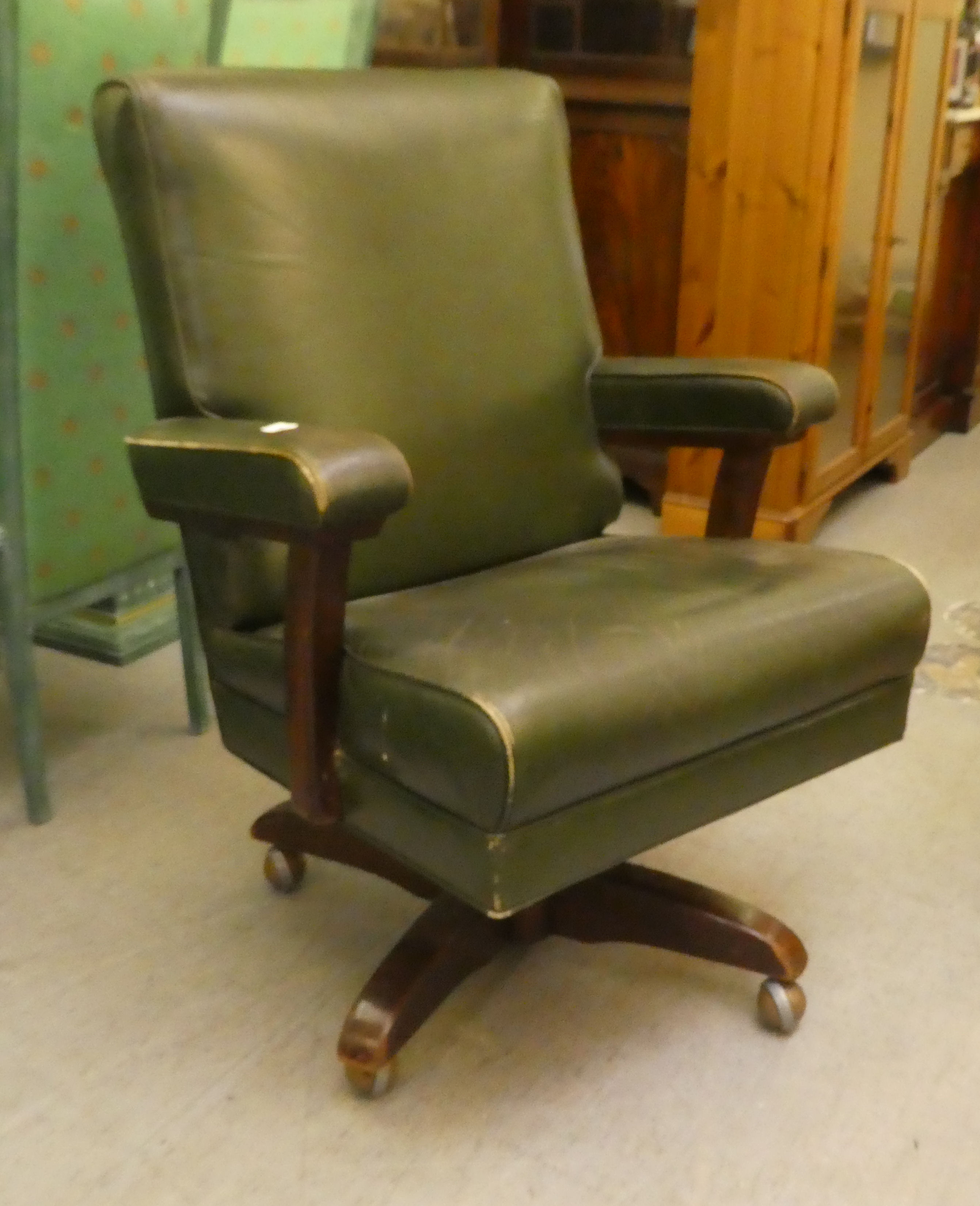 A mid 20thC faux green hide upholstered swivel office chair, raised on a splayed pedestal base