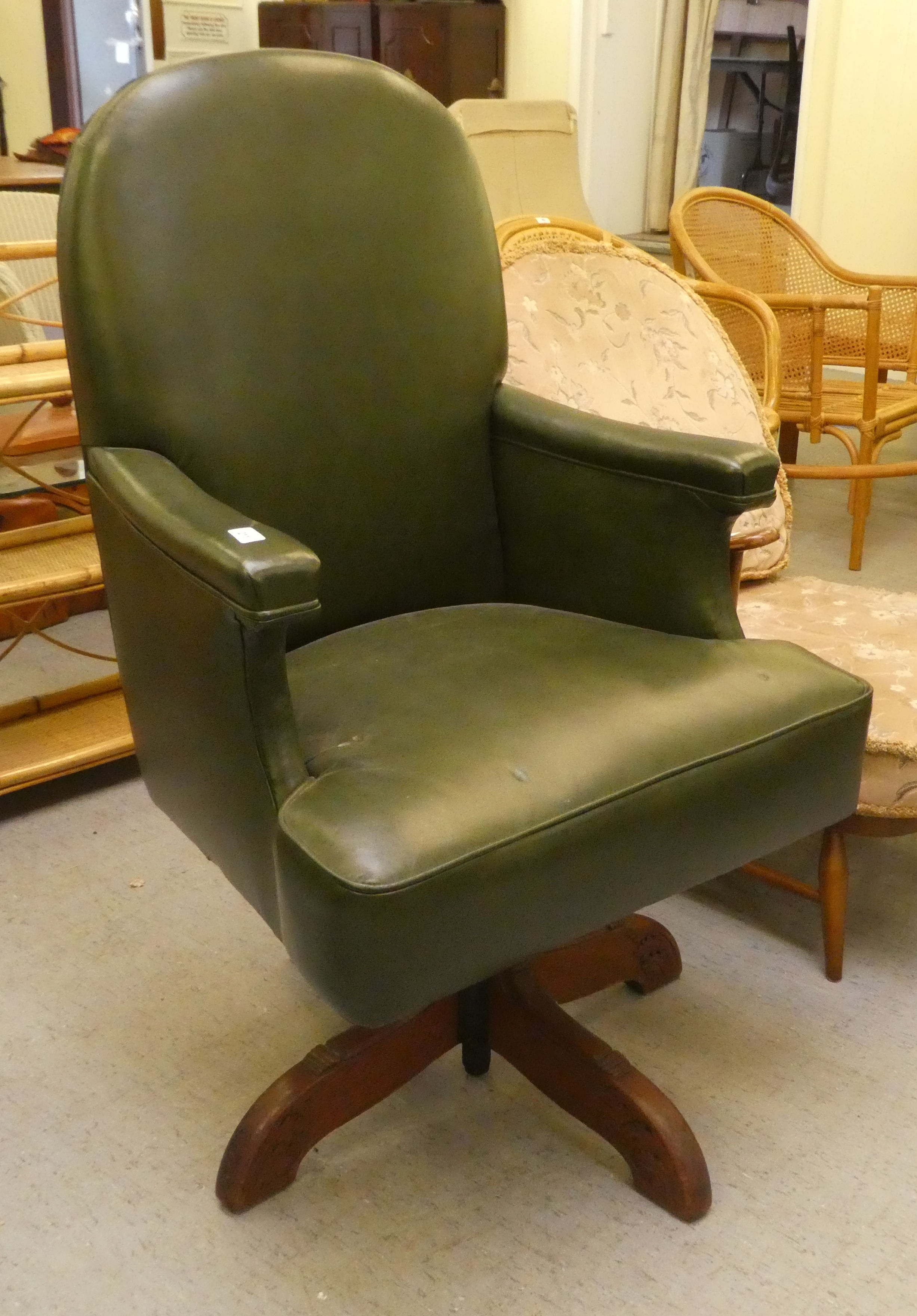 A mid 20thC faux green hide upholstered swivel office chair, raised on a splayed pedestal base