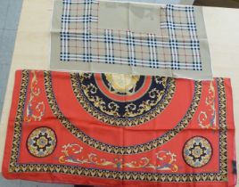 A Versace silk scarf on a red ground; and a Burberry's silk scarf