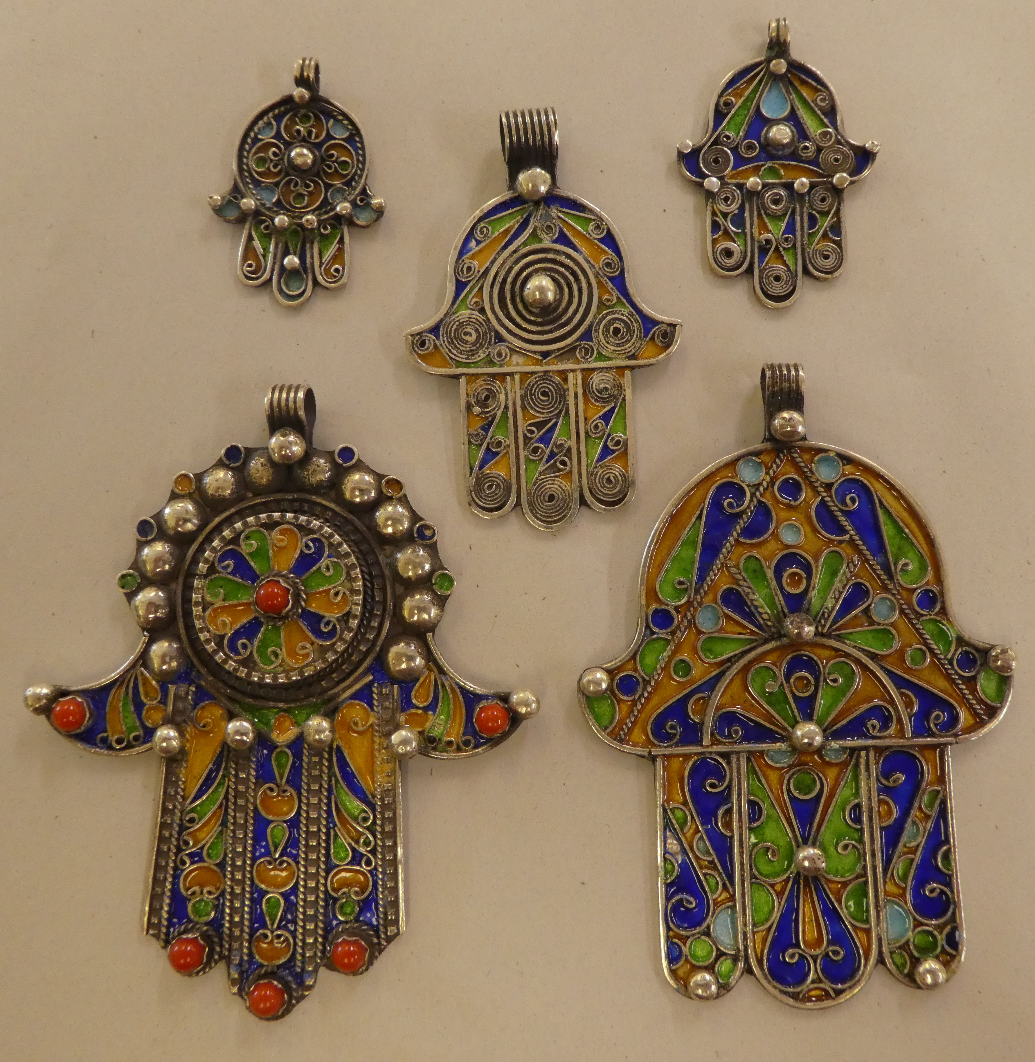 Five Hamsa white metal and multi-coloured enamel pendants