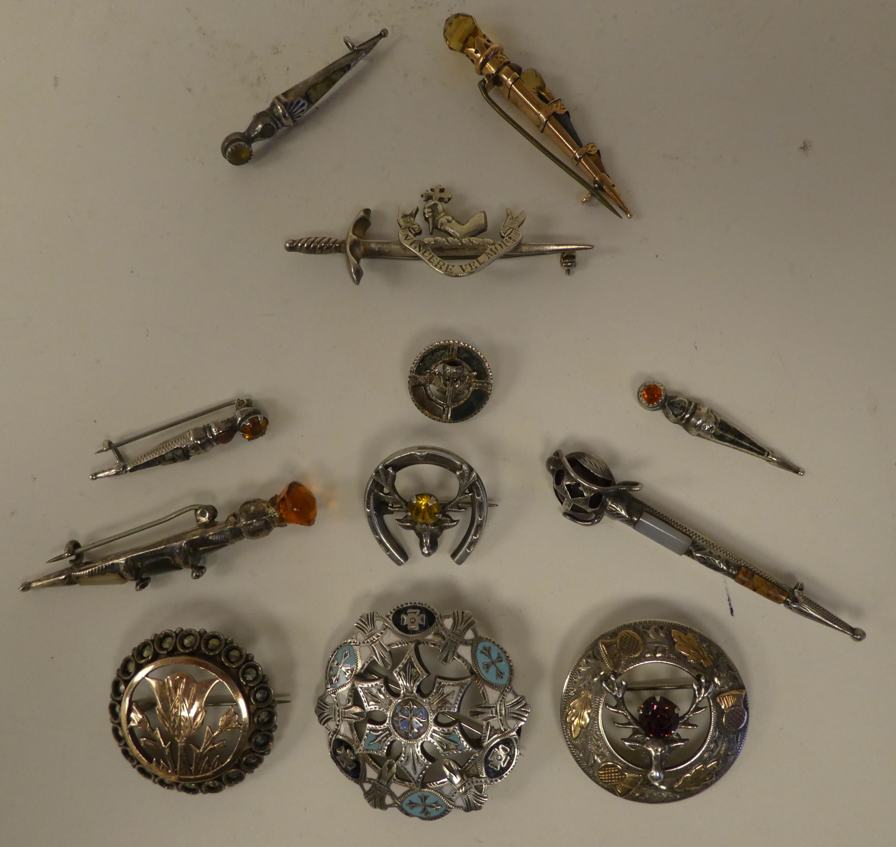 Scottish pin brooches: to include Sterling and other silver and yellow metal sword brooches