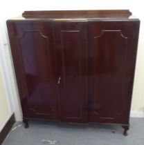 A mid 20thC mahogany breakfront cabinet with three panelled doors, raised on cabriole legs  52"h