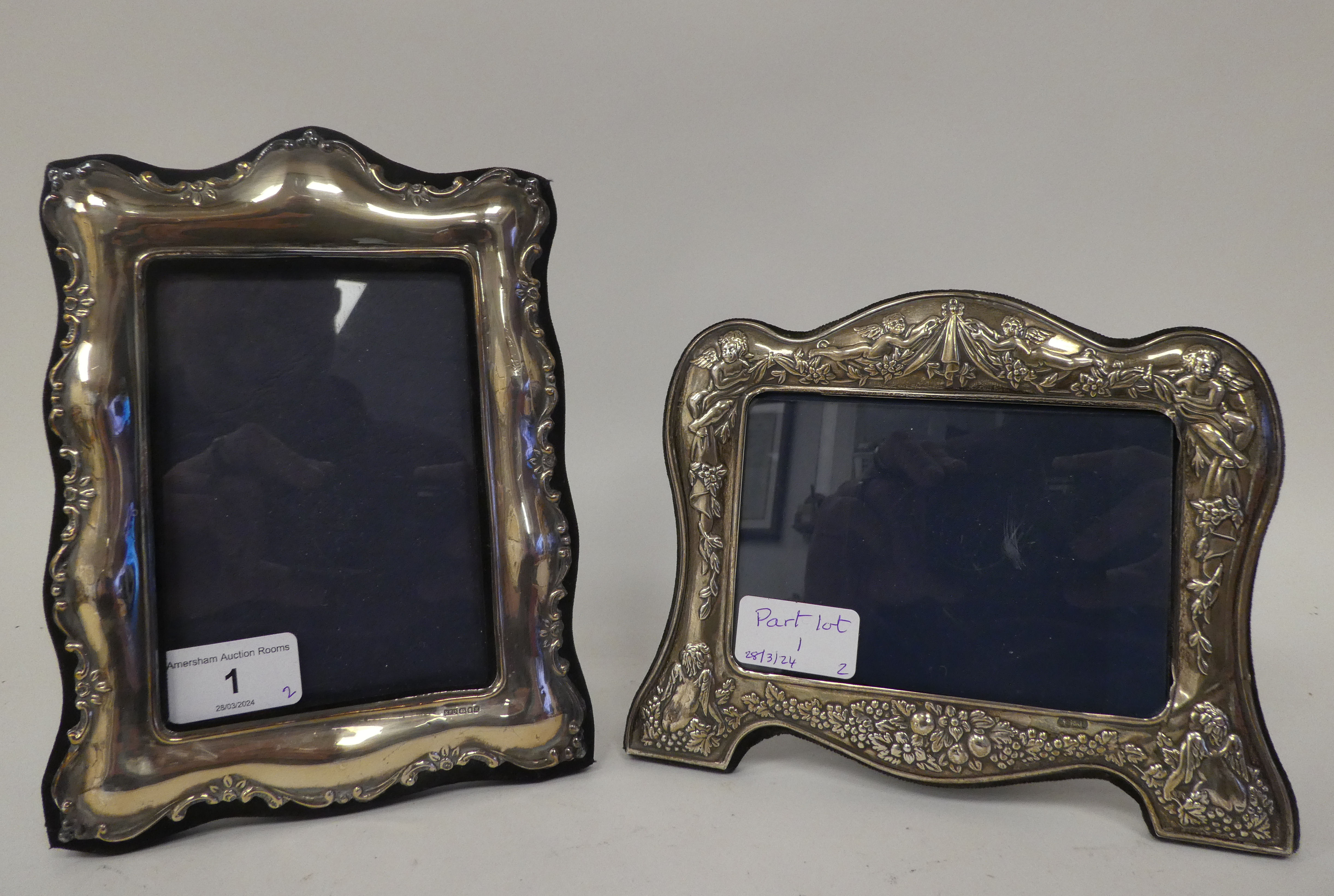 Two dissimilar, glazed, silver mounted photograph frames with embossed ornament, fabric backs and