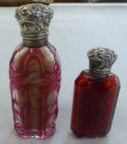 Two late Victorian Cranberry glass scent bottles, each with a hinged silver lid  indistinct marks