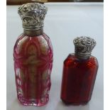 Two late Victorian Cranberry glass scent bottles, each with a hinged silver lid  indistinct marks