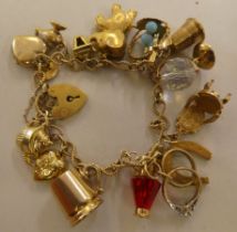 A 9ct and gold coloured metal charm bracelet, on a padlock clasp