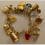 A 9ct and gold coloured metal charm bracelet, on a padlock clasp