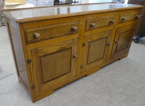 A 20thC oak dresser with three inline frieze drawers, over three panelled doors, on a plinth  33"