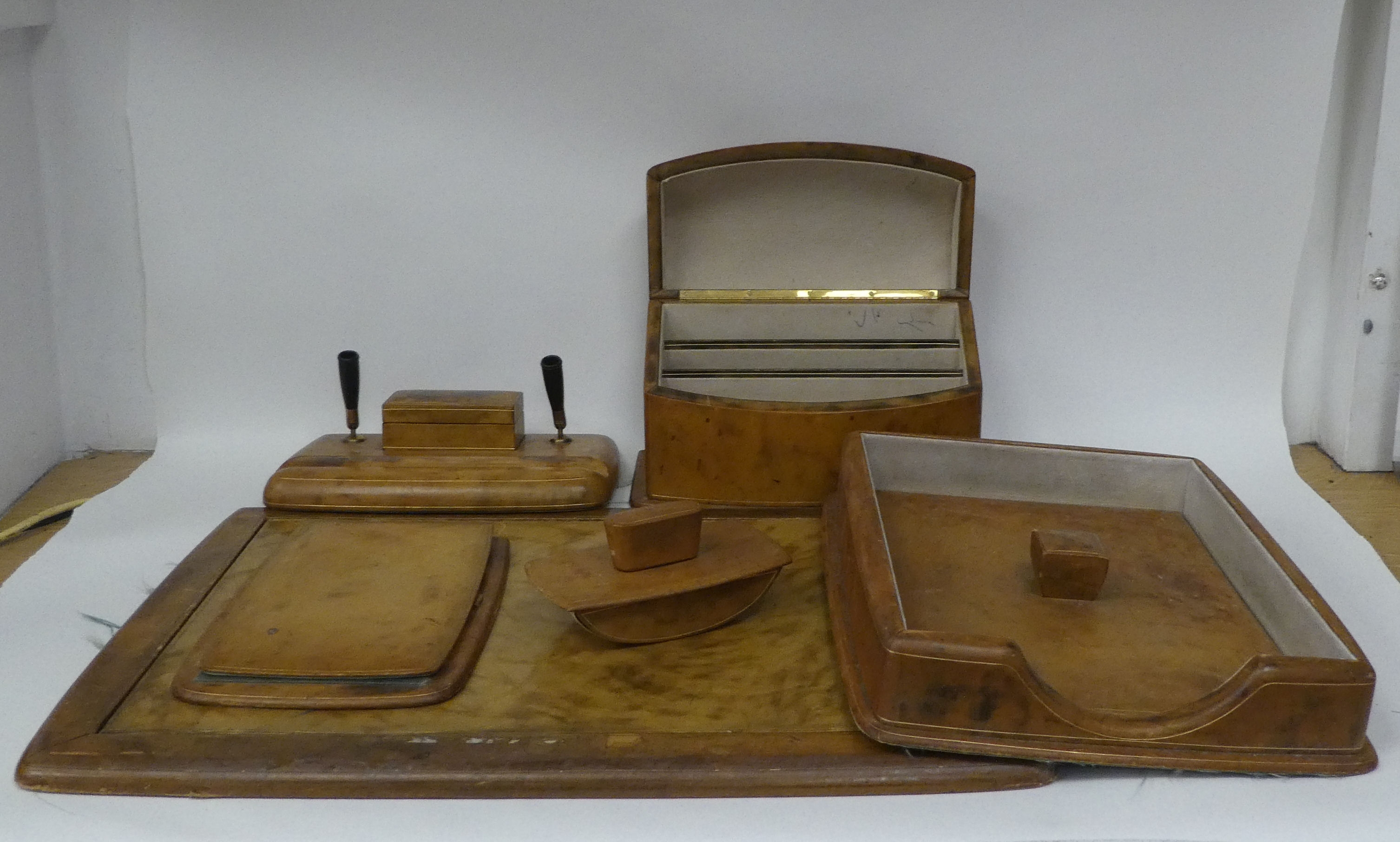 An Italian gilded and burnished mid-brown hide covered desk set, comprising a two-part blotter