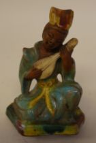 A late 18thC Chinese glazed pottery figure, a seated woman playing a stringed instrument  4"h