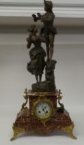 A late 19thC French mantel clock, the mottled iron red marble case surmounted by a painted spelter