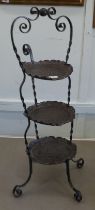 An Art Nouveau inspired wrought iron framed and spot-hammered three tier brass tray cakestand  32"h