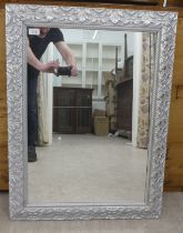 A modern mirror, the plate set in a silvered effect frame  25" x 32"