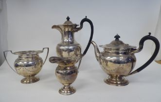 A four piece silver tea set of bulbous, pedestal form with egg and dart borders, engraved, ribbon