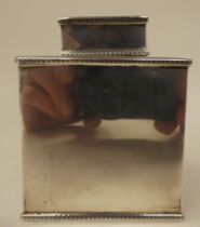 A silver tea caddy of rectangular box design with a cover and egg and dart cast ornament