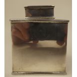 A silver tea caddy of rectangular box design with a cover and egg and dart cast ornament