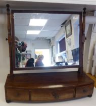 A Regency toilet mirror, the plate set in a mahogany frame, pivoting on turned, angled horns and a