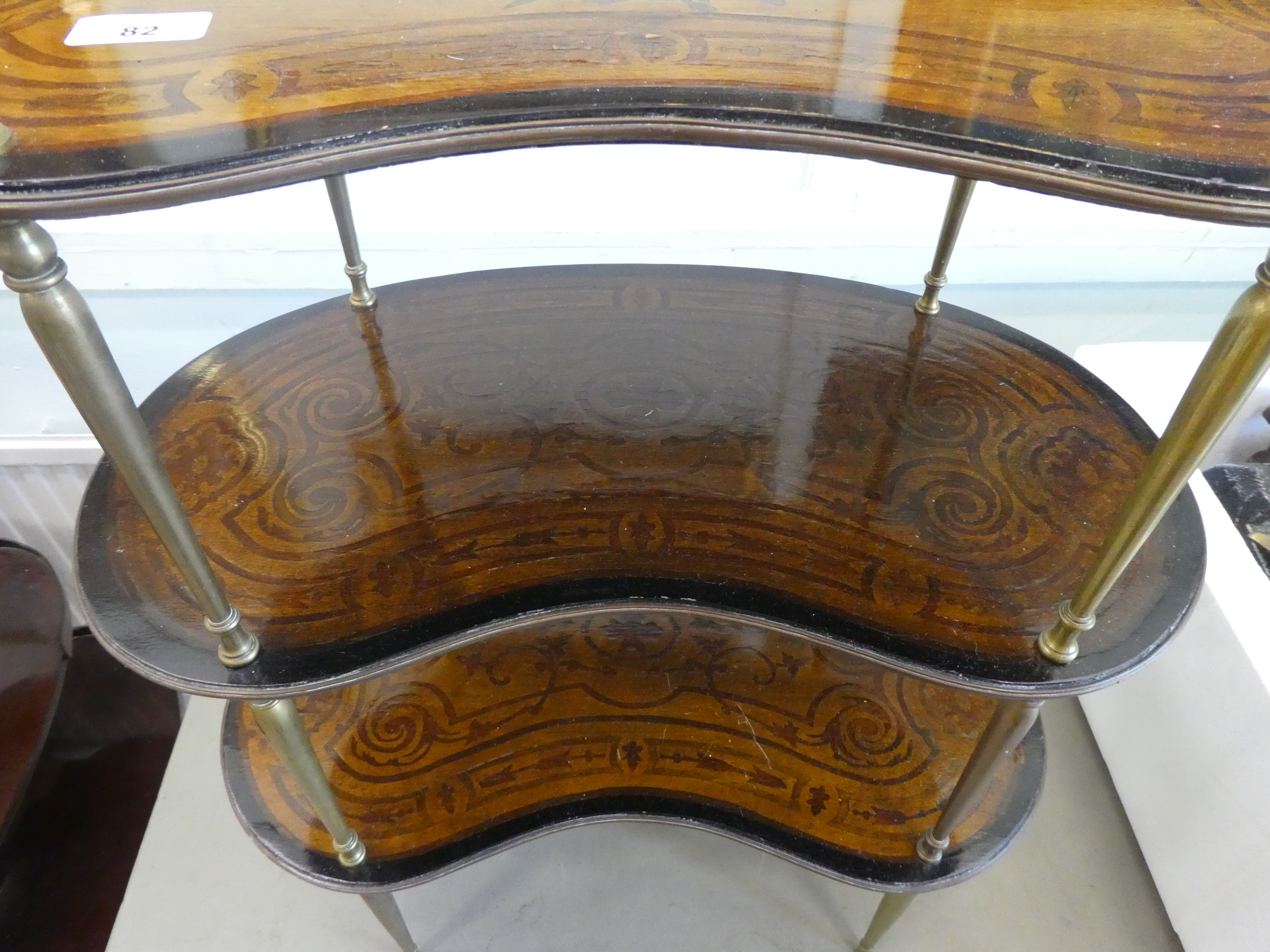 An early 20thC overpainted mahogany kidney shaped three tier whatnot, elevated on tapered, brass - Image 3 of 4