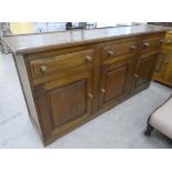 A 20thC oak dresser with three inline frieze drawers, over three panelled doors, on a plinth  33"