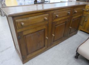 A 20thC oak dresser with three inline frieze drawers, over three panelled doors, on a plinth  33"